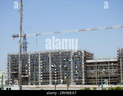 Cairo, Egitto, 21 luglio 2023: Un cantiere di un nuovo edificio industriale con ponteggi e gru di Hassan Allam Construction with the Waving Foto Stock