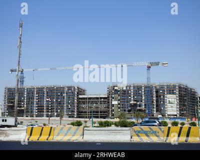 Cairo, Egitto, 21 luglio 2023: Un cantiere di un nuovo edificio industriale con ponteggi e gru di Hassan Allam Construction with the Waving Foto Stock