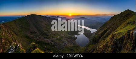 Snowdonia. La vista del sorgere del sole dalla cima del Monte Snowdon, Yr Wyddfa, guardando ad est verso il lago Glaslyn (la macchina fotografica più vicina) e Llyn Llydaw dietro. Foto Stock