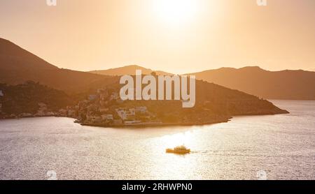 Isola di Symi, Grecia. Vacanze nelle isole della Grecia da Rodi nel Mar Egeo. Case colorate in stile neoclassico nella baia di Symi. vista della baia principale dell'isola, dove attraccano traghetti turistici e yacht Foto Stock