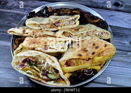 Patate fritte sandwich a dita e pane piatto con purè di fave e tradizionali panini egiziani con dinamite farciti di fave, uova, gre Foto Stock