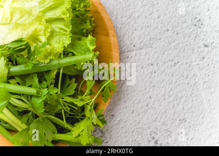 Cipolle verdi biologiche, erba cipollina, lattuga e prezzemolo su tavola di pietra Foto Stock