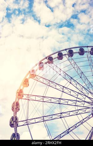 Immagine a colori di una ruota panoramica contro il cielo, con tonalità di colore applicata. Foto Stock