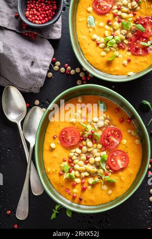 Zuppa di lenticchie fatta in casa con panna e pomodori ciliegini. Zuppa gialla di lenticchie a base di verdure. Foto Stock