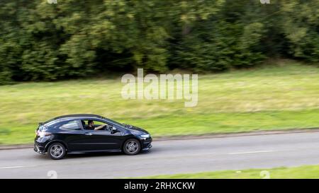 Milton Keynes, Regno Unito - 16 agosto 2023: 2011 auto Honda Civic nera che viaggia su una strada di campagna inglese. Foto Stock