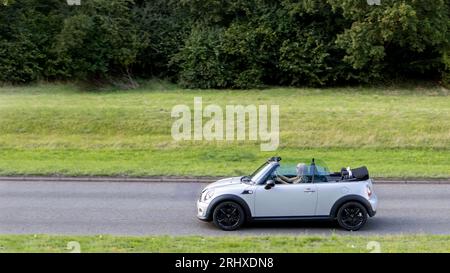 Milton Keynes, Regno Unito - 16 agosto 2023: 2011 R57 Mini Cooper Convertible car che viaggia su una strada inglese Foto Stock