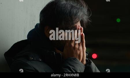 Da vicino senzatetto preoccupato ansia triste ha sottolineato arabo infelice uomo in città oscura doloroso mal di testa infortunio malato ragazzo in bancarotta da uomo d'affari stress Foto Stock