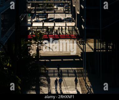 I pedoni urbani proiettano lunghe ombre nel pomeriggio, con una vista della silhouette astratta e ad angolo elevato Foto Stock