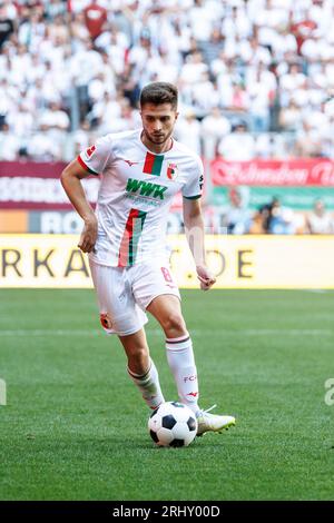 Augusta, Germania. 19 agosto 2023. Calcio: Bundesliga, FC Augsburg - Borussia Mönchengladbach, Matchday 1, WWK Arena. Elvis Rexhbecaj di Augusta gioca la palla. Credito: Matthias Balk/dpa - NOTA IMPORTANTE: conformemente ai requisiti della DFL Deutsche Fußball Liga e della DFB Deutscher Fußball-Bund, è vietato utilizzare o far utilizzare fotografie scattate nello stadio e/o della partita sotto forma di immagini di sequenza e/o serie di foto simili a video./dpa/Alamy Live News Foto Stock