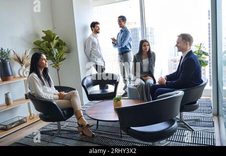 Personale internazionale che parla nell'atrio dell'ufficio. Scatti autentici Foto Stock