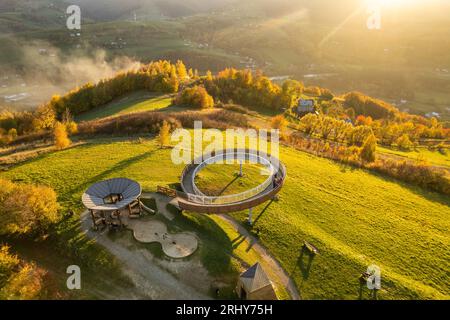 Vista aerea di una torre di osservazione in legno sulle montagne autunnali al tramonto in Polonia Foto Stock