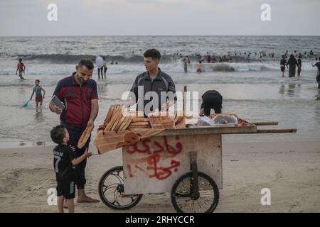 19 agosto 2023, Gaza City, Gaza Strip, Palestina: Un uomo palestinese vende pane sulla spiaggia nella parte occidentale della città di Gaza, Striscia di Gaza il 19 agosto 2023. Vita quotidiana nella città di Gaza in mezzo a temperature elevate e interruzioni di corrente durante il blocco israeliano in corso il 19 agosto 2023. Per i palestinesi che vivono a Gaza, l'affollata Striscia di Gaza, c'è un'ondata di calore che peggiora in estate a causa di interruzioni di corrente dovute al continuo blocco israeliano. (Immagine di credito: © Mahmoud Issa/Quds Net News via ZUMA Press Wire) SOLO USO EDITORIALE! Non per USO commerciale! Foto Stock