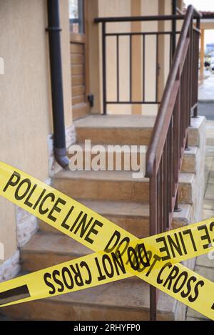 Il nastro giallo della scena del crimine blocca le scale all'aperto Foto Stock