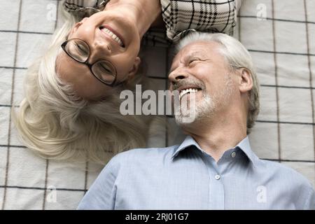 Una coppia di anziani che si rilassa sul letto e si rilassa Foto Stock