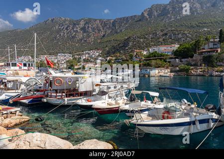 Porto di Kas fiancheggiato da barche e montagne sullo sfondo. Kas è una città di mare sulla costa mediterranea nel sud-ovest della Turchia. Foto Stock