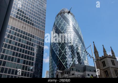 Londra, Regno Unito. 10 agosto 2023. Il contemporaneo edificio Gherkin nella City di Londra. Wikapedia lo elenca come 'formalmente 30 St Mary Axe e precedentemente noto come Swiss Re Building, è un grattacielo commerciale nel principale distretto finanziario di Londra, la City of London. È stato completato nel dicembre 2003 e inaugurato nell'aprile 2004. Con 41 piani, è alto 180 metri (591 piedi) e sorge sui siti dell'ex Borsa Baltica e camera di navigazione, che sono stati ampiamente danneggiati nel 1992 nell'attentato alla Borsa del Baltico da un dispositivo posto dall'IRA provvisorio a St Mary Axe, una stretta strada Foto Stock