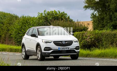 Woburn, Beds, UK - 19 agosto 2023: Auto bianca 2019 Vauxhall Grandland SUV che viaggia su una strada di campagna inglese. Foto Stock