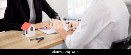 Giovane uomo cliente parlare con l'agente di contratto di acquisto casa e l'accordo di ipoteca immobiliare e spiegare per la pianificazione in casa ufficio Foto Stock