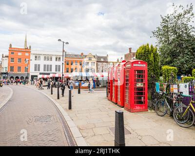 Quattro vivaci cabine telefoniche rosse raffigurate nell'agosto 2023 accanto al Cambridge Market mentre passavano le persone. Foto Stock