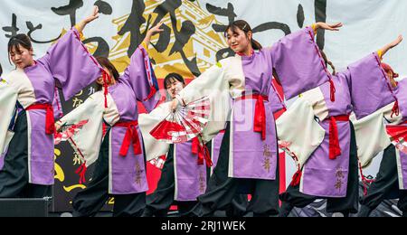 Ragazze giapponesi adolescenti squadra di danza Yosakoi in tuniche yukata e tenendo i fan su un palco all'aperto che balla al festival annuale di Kumamoto Kyusyu Gassai Foto Stock