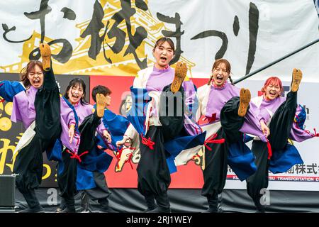 Squadra di danza giapponese Yosakoi in yukata su un palco all'aperto che balla e fa le gambe al festival Kumamoto Kyusyu Gassai. Foto Stock