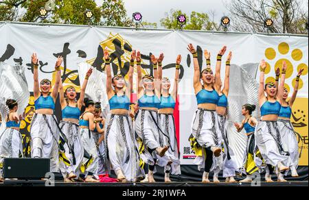 Squadra di danza giapponese Yosakoi con costumi d'argento e blu su un palco all'aperto che balla all'annuale festival Kumamoto Kyusyu Gassai. Foto Stock