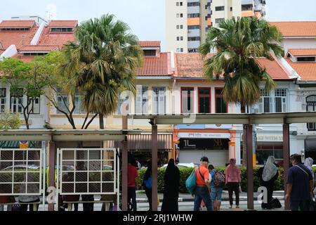La gente aspetta un autobus a Geylang, un'area con una percentuale maggiore di residenti etnici malesi, a Singapore. 21/08/2022 Foto Stock