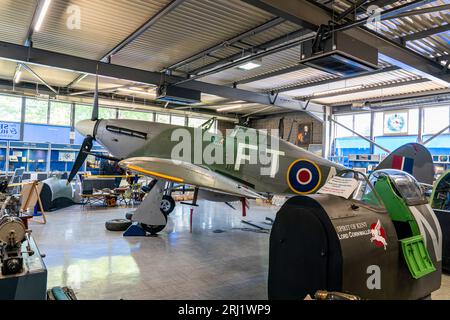 RAF Hurricane II in mostra all'interno del museo commemorativo Spitfire and Hurricane nell'ex aeroporto RAF Manston nel Kent. Vista laterale dell'aereo. Foto Stock