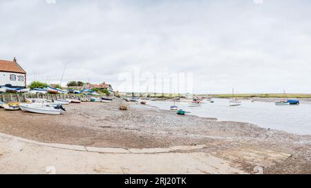 Un panorama multi immagine che si affaccia sullo scalo di Burnham Overy Staithe sulla costa del Norfolk settentrionale visto con la bassa marea nell'agosto 2023. Foto Stock