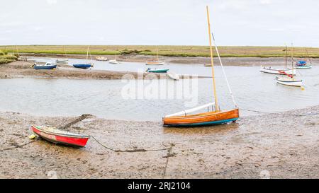 Un panorama multi immagine delle barche che costeggiano Burnham Overy Staithe sulla costa del Norfolk settentrionale visto nell'agosto 2023. Foto Stock