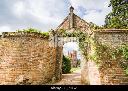 Oxburgh Hall nella foto attraverso un vecchio arco in mattoni a Norfolk, visto nell'agosto 2023. Foto Stock