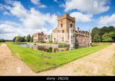 Oxburgh Hall nella foto sotto un cielo blu nell'agosto 2023 circondata da un sentiero e fossato nel cuore del Norfolk. Foto Stock