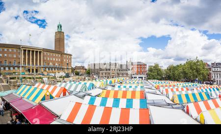 Un panorama multi immagine con i tetti a strisce del Norwich Market, circondato dal Norwich City Hall e dalla Norwich Guildhall nell'agosto 2023. Foto Stock