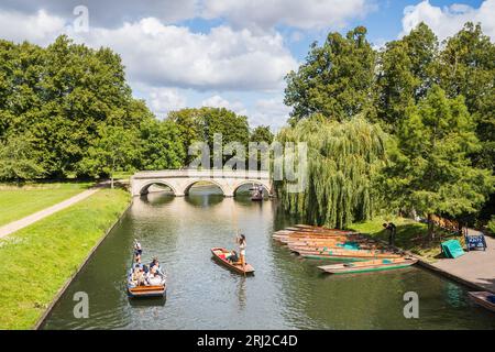 Punt che portano i turisti lungo il fiume Cam nell'agosto 2023 di fronte al Trinity Bridge, Cambridge. Foto Stock
