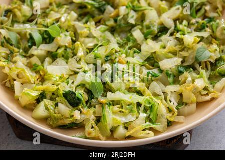 Cavolo saltato con erbe in una padella di ghisa, idea di contorno vegetale sano Foto Stock