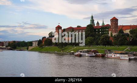 Il bellissimo vecchio castello reale di Wawel sulle rive del fiume Vistola in serata. Il principale punto di riferimento storico di Cracovia, una popolare destinazione turistica i Foto Stock