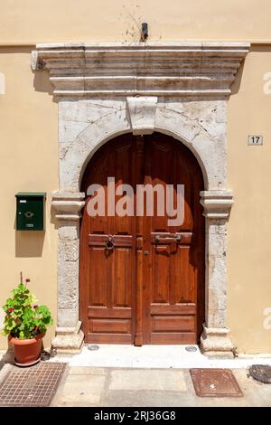 Vecchia porta di legno con architrave ad arco in pietra in un'antica residenza nel centro storico di Rethymno, nell'isola di Creta, in Grecia, in Europa. Foto Stock