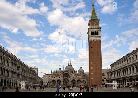 San Marco a Venezia, in Italia, mostra l'antica architettura della città circondata da persone che si godono il bellissimo cielo blu Foto Stock