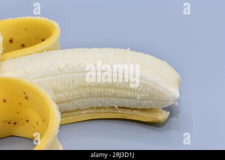 Una banana sbucciata distesa. Foto Stock