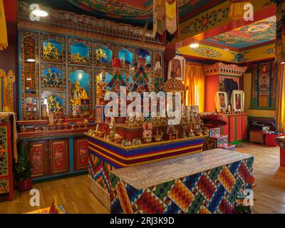 Questa immagine cattura un interno vibrante e decorato di un tempio buddista caratterizzato da intricate decorazioni in una moltitudine di colori Foto Stock