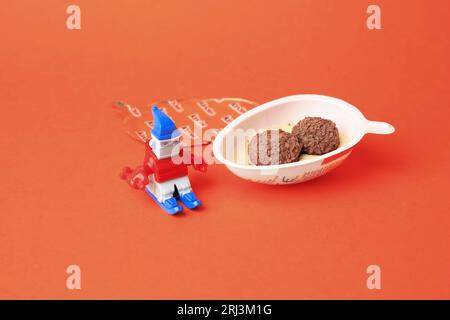 Slynchev Bryag, Bulgaria - 25 maggio 2023: Metà dell'uovo Kinder Joy con caramelle dolci e giocattolo su sfondo arancione Foto Stock