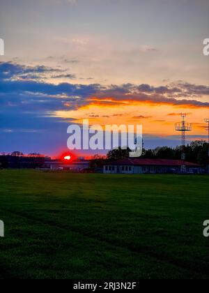 Uno scatto verticale di un tramonto mozzafiato in un cielo vibrante con sfumature di arancione e blu Foto Stock