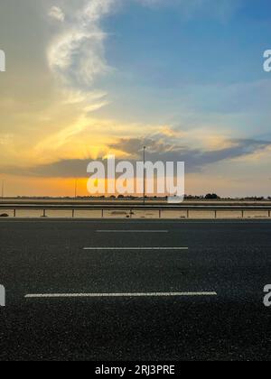 Un bellissimo tramonto illumina un'autostrada Foto Stock