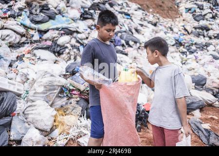 Povertà in India, un bambino raccoglie spazzatura in una discarica, concetto di sostentamento dei bambini poveri. Lavoro minorile. Lavoro minorile, traffico di esseri umani, po Foto Stock