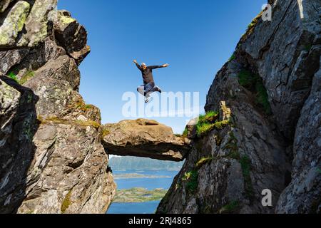 L'uomo felice sta saltando in cima alla montagna. Si rallegra per il successo della vittoria su se stesso, superando se stesso. Foto Stock
