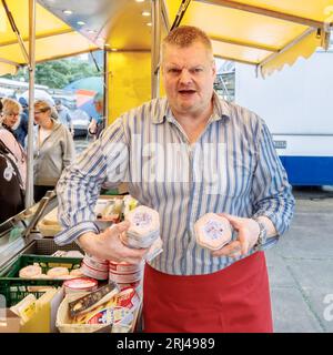 Amburgo, Germania. 23 luglio 2023. Axel Pabst vende formaggio al mercato del pesce di Amburgo. Da più di 25 anni Axel Pabst lavora come market crier per l'azienda Fred4Food, che è diventata nota nel mercato del pesce attraverso il commercio di frutta Bananen-Fred. Nel frattempo, però, non c'è più solo frutta nell'assortimento, ma anche, tra le altre cose, il proprio stand di formaggi. Meglio conosciuto come: Cheese-Fred. (A dpa: "Gridare per Käse-Fred - un venditore di pesce in missione") credito: Markus Scholz/dpa/Alamy Live News Foto Stock