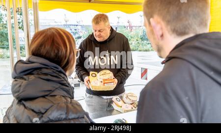 Amburgo, Germania. 23 luglio 2023. Axel Pabst vende formaggio al mercato del pesce di Amburgo. Da più di 25 anni Axel Pabst lavora come market crier per l'azienda Fred4Food, che è diventata nota nel mercato del pesce attraverso il commercio di frutta Bananen-Fred. Nel frattempo, però, non c'è più solo frutta nell'assortimento, ma anche, tra le altre cose, il proprio stand di formaggi. Meglio conosciuto come: Cheese-Fred. (A dpa: "Gridare per Käse-Fred - un venditore di pesce in missione") credito: Markus Scholz/dpa/Alamy Live News Foto Stock