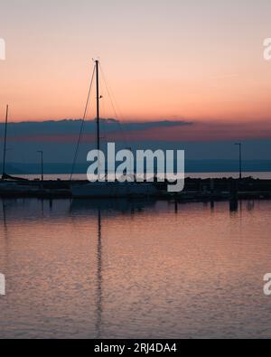 Il tranquillo specchio d'acqua con barche a vela ormeggiate vicino al molo. Foto Stock