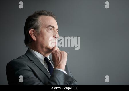 Ritratto di un imprenditore che sta riflettendo sulle idee per lo sviluppo aziendale Foto Stock
