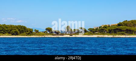 Cannes, Francia - 31 luglio 2022: Panorama dell'isola di Ile Sainte Marguerite con il castello del forte reale e yacht che naviga sulle acque del Mar Mediterraneo Foto Stock